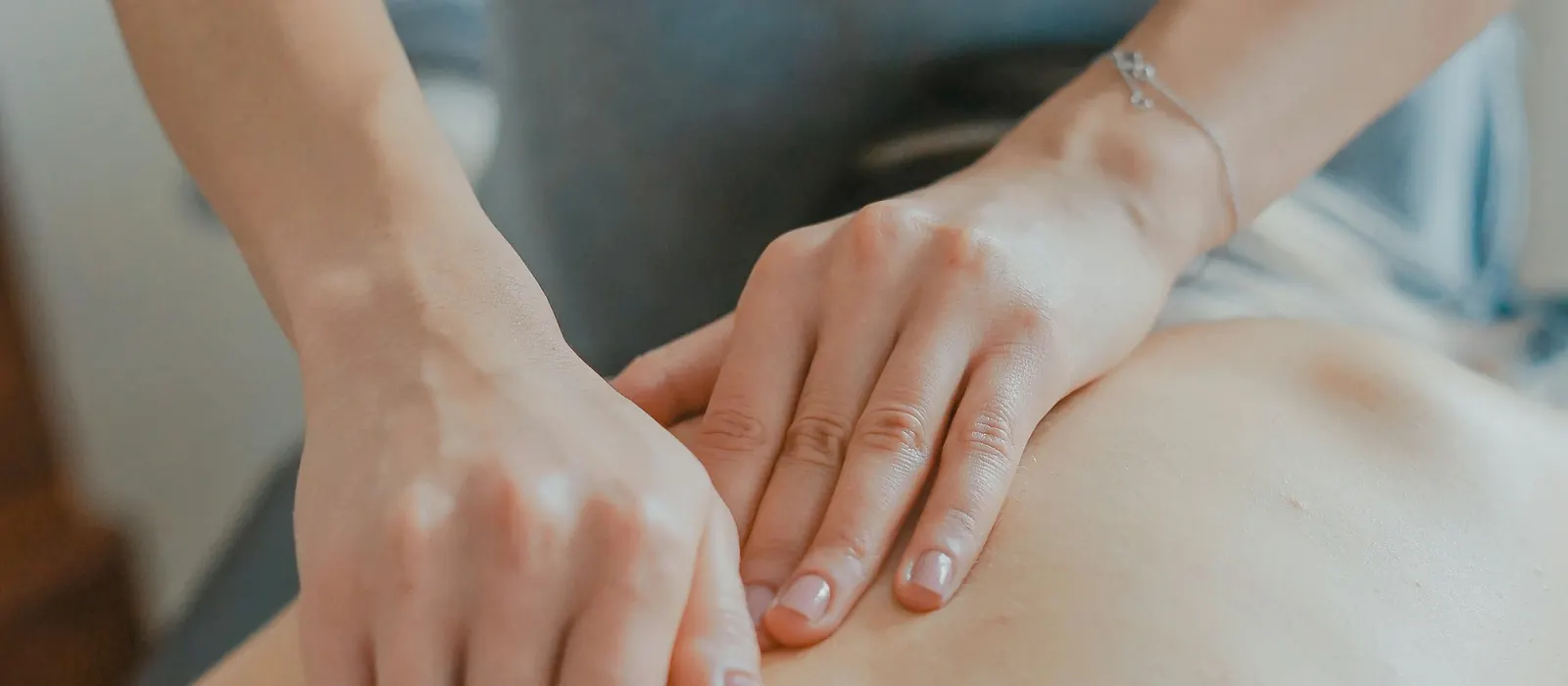 Mains de massothérapeute travaillant les tissus du dos