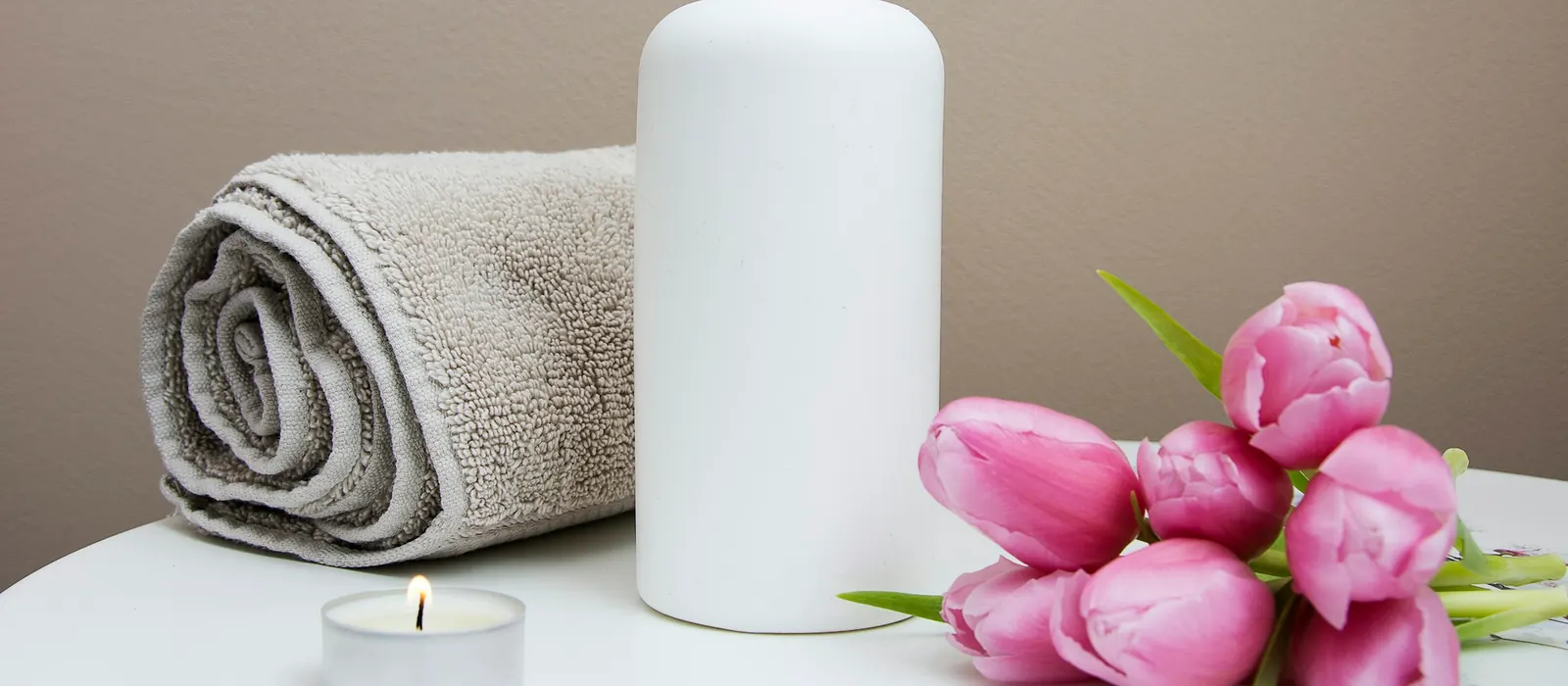 Serviette, lotion et chandelle préparées pour une séance douce