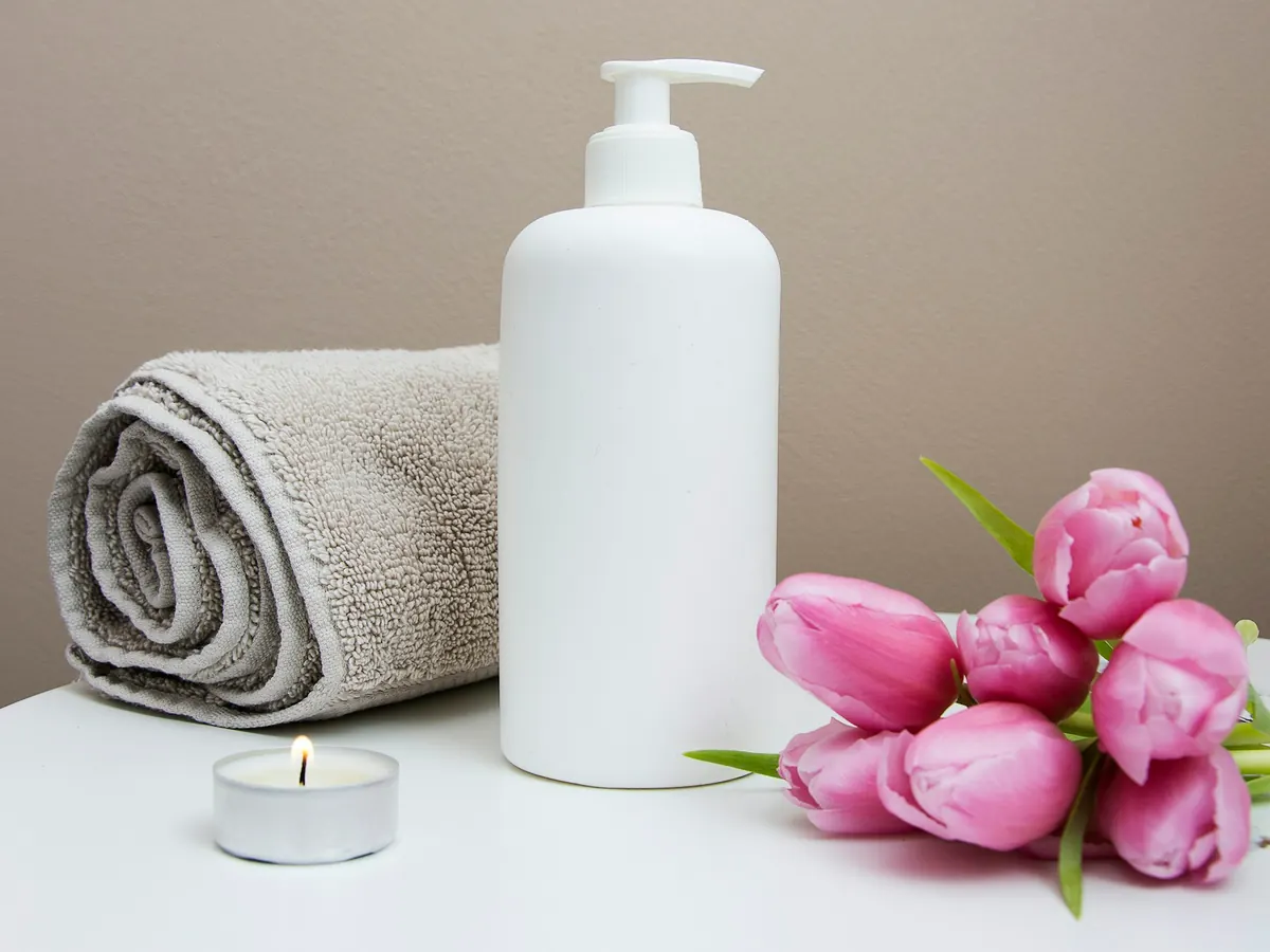 Serviette, lotion et chandelle préparées pour une séance douce